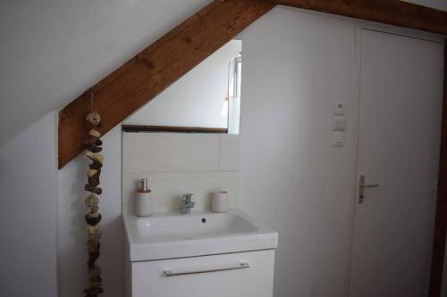 La salle de bains est pourvue d'un lavabo et d'une porte blancs. dans l'établissement les hirondelles, à Fécamp