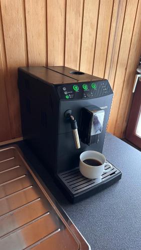 a coffee maker with a cup of coffee on a table at Pension Asel in Wörth am Rhein