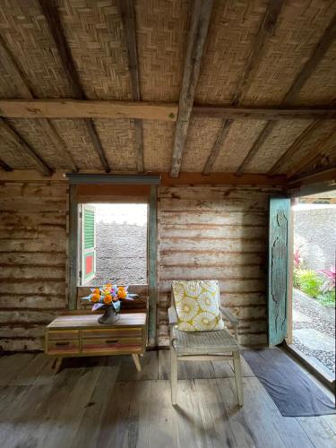 a room with a bed and a chair and a window at Oemah Gebagan 78 Akasha Room B&B in Karangasem