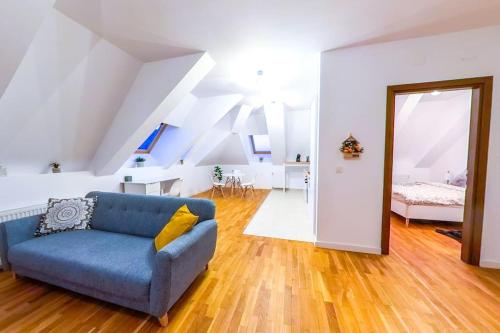 a living room with a blue couch and a bedroom at Bucharest Central D Apartment in Bucharest