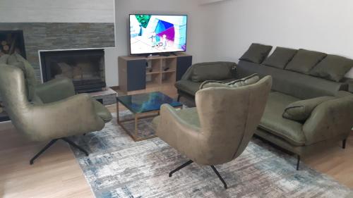 a living room with a couch and chairs and a television at Mavrovo Centar Ski Staza in Mavrovo