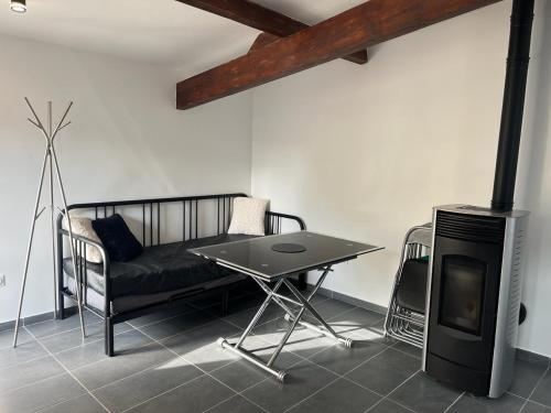 a living room with a couch and a table and a stove at Maison toute équipée à Grézieu la Varenne in Grézieu-la-Varenne