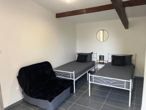 a room with two beds and a chair at Maison toute équipée à Grézieu la Varenne in Grézieu-la-Varenne
