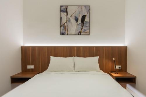 a bedroom with a large white bed and wooden headboard at STAYS HOTEL in Kuala Lumpur