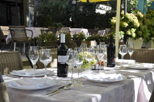 a table with wine glasses and wine bottles on it at Villa Klia in Ohrid