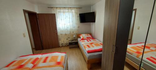 Habitación pequeña con 2 camas y TV. en Apartment Popp Heilbronn, en Heilbronn