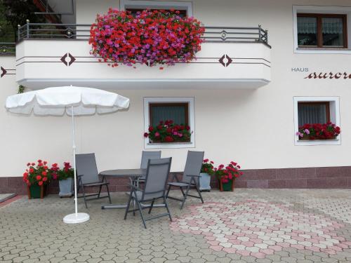 een patio met stoelen en een parasol voor een gebouw bij Lovely Apartment with Infrared Sauna in Kappl in Kappl