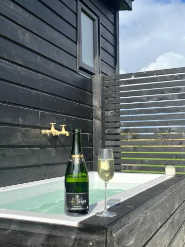 a bottle of wine and a glass sitting on a ledge at Wild Hideaways Luxury Lodges and Eco Spa in Bantry