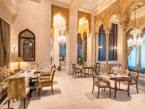 a dining room with tables and chairs and windows at Mövenpick Hotel Al Khobar in Al Khobar