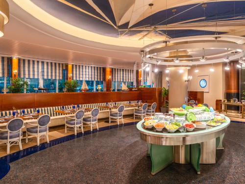 a dining room with a table with food on it at Mövenpick Hotel Al Khobar in Al Khobar