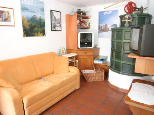 a living room with a couch and a tv at Holiday home in Wernberg with pool and sauna in Wernberg