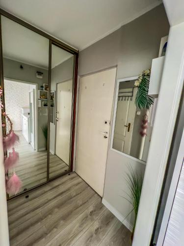 pasillo con puerta de cristal y espejo en Apartament by Wyszyńskiego Street en Konin