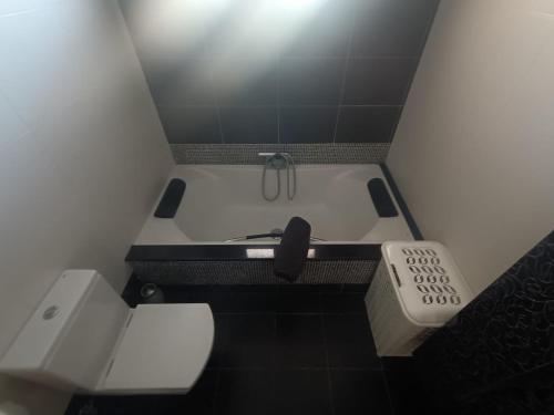 ein kleines Bad mit einer Badewanne mit Fernbedienung in der Unterkunft Casa Vera in A Guarda
