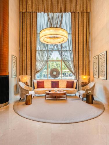 a living room with a couch and a large window at Mövenpick Hotel Al Khobar in Al Khobar