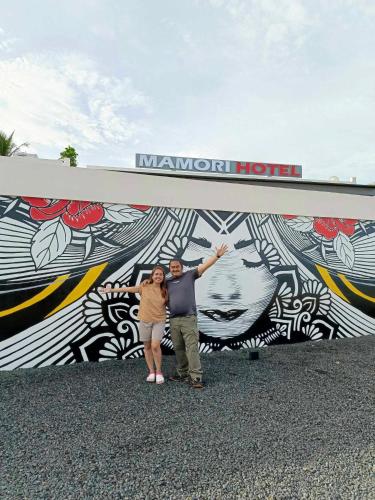 a man and woman standing in front of a mural at MAMORI HOTEL in Allen