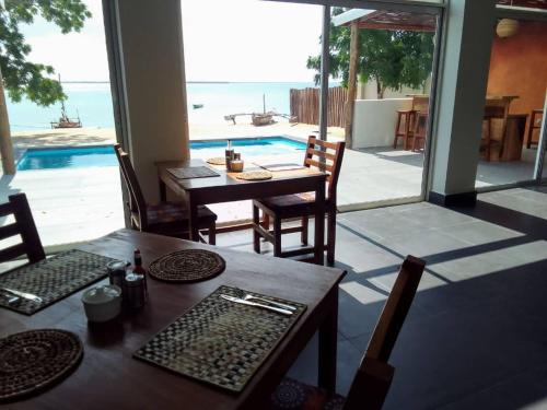 - une salle à manger avec une table, des chaises et une piscine dans l'établissement Matumaini Guest House, à Migogoni