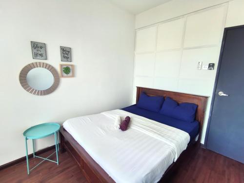 a bedroom with a bed with blue pillows and a stool at Apartment in Ladang Tok Pelam - Hana Home by the Sea in Kuala Terengganu