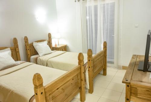 a bedroom with two beds and a television in it at Sol & Lar No stress in Santa Maria