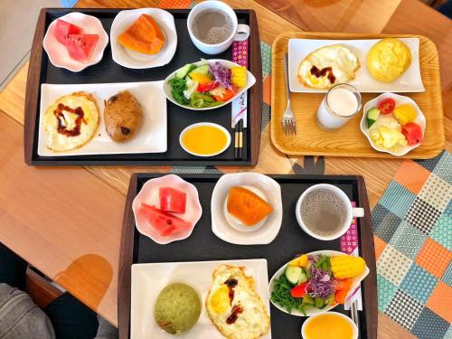 a table with three trays of food on it at XinFu Traveler Inn in Taiping