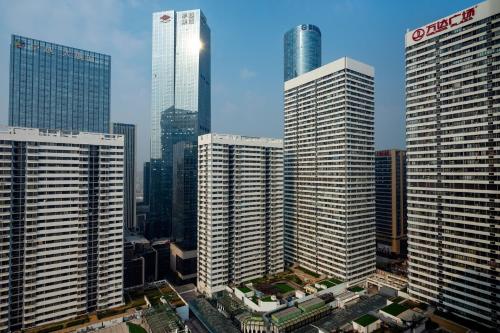um grupo de edifícios altos em uma cidade em Le Meridien Qingdao em Qingdao