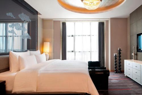 a bedroom with a large bed and a large window at Le Méridien Qingdao l Instagrammable l CBD l Nearby seaside,nearby May 4th Square in Qingdao