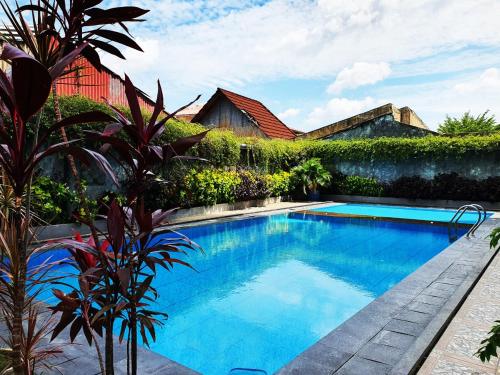 a swimming pool in front of a house at favehotel Olo Padang in Padang