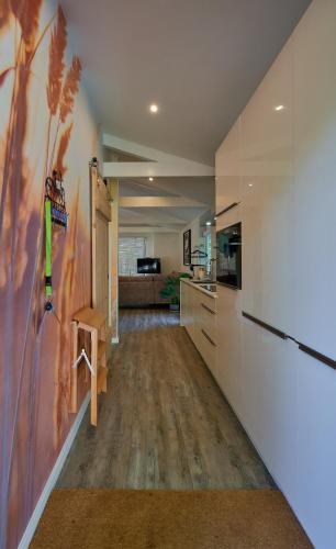 a hallway of a kitchen with a refrigerator and cabinets at ZEN-Bungalow no 5 met sauna en hottub in Rheezerveen