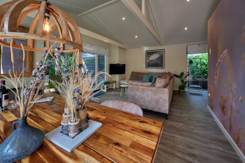 a living room with a table and a couch at ZEN-Bungalow no 5 met sauna en hottub in Rheezerveen