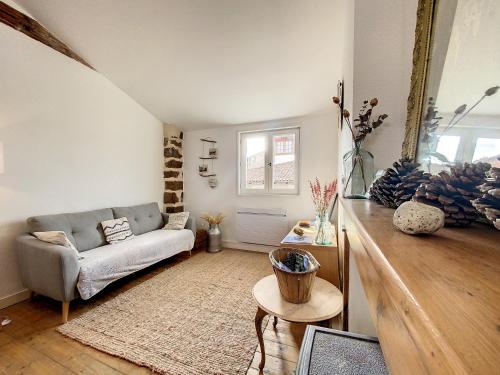 un soggiorno con divano e tavolo di Maison atypique - centre historique - Puy en Velay a Le Puy en Velay