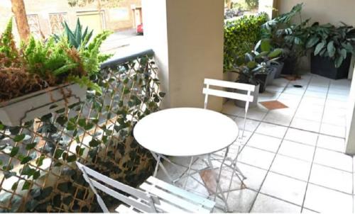 a white table and chairs on a patio with plants at Resort Style 2BR Apt in Pyrmont Next to Darling Harbour in Sydney