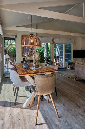 a dining room with a wooden table and chairs at ZEN-Bungalow no 5 met sauna en hottub in Rheezerveen