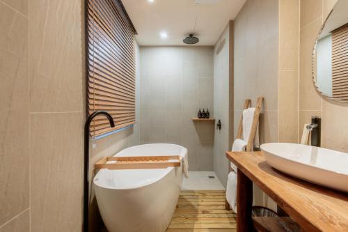 a bathroom with a large tub and a sink at Just Inn Kaohsiung in Kaohsiung