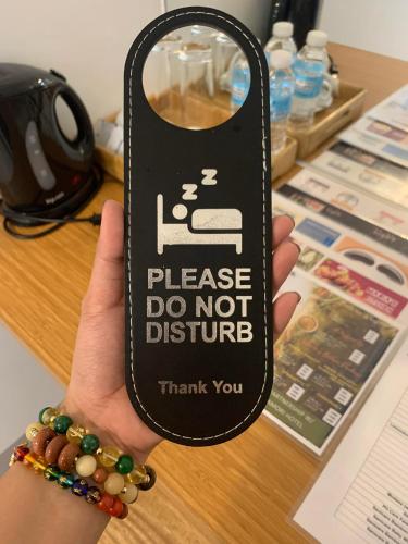 a hand holding a sign that says please do not disturb at MAMORI HOTEL in Allen
