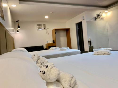 two beds in a hotel room with two teddy bears at MAMORI HOTEL in Allen