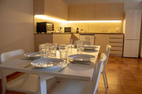 a white table with plates and glasses on it in a kitchen at Can Carles - Delta del Ebro in El Poblenou del Delta