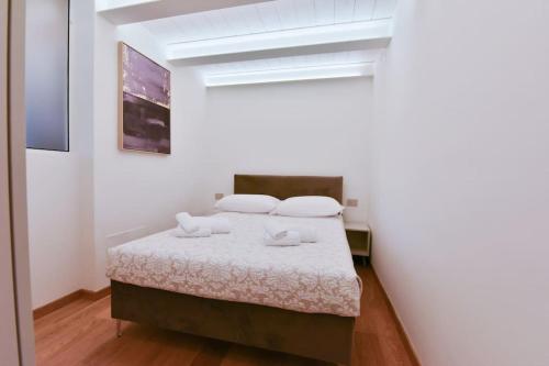 a bedroom with a bed in a white room at Loft 21 - Lussuoso ed Elegante a due passi dal Mare in Finale Ligure