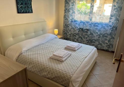 una camera da letto con un letto e due asciugamani di Appartamento Il Girasole a Terni, Umbria a Terni