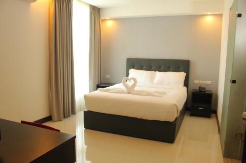 a hotel room with a bed with a swan on it at The Pacifico Boutique Hotel in Cagayan de Oro