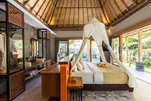 a bedroom with a bed with a mosquito net at Govinda Villas in Penginyahan