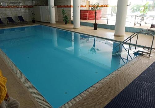 ein großer Pool mit blauem Wasser in einem Gebäude in der Unterkunft Ferienwohnung INA am Bodensee mit Schwimmbad und Sauna in Uhldingen-Mühlhofen