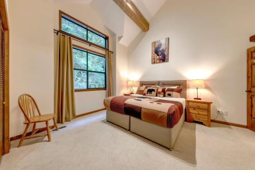 ein Schlafzimmer mit einem Bett, einem Stuhl und einem Fenster in der Unterkunft Northern Lights 21 in Whistler