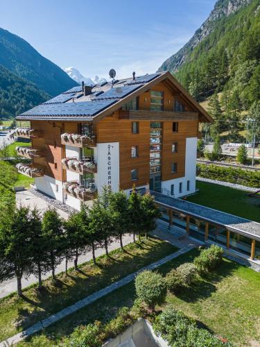 an aerial view of a building with mountains in the background at Hotel Taescherhof in Täsch