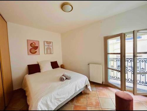une chambre avec un lit et une grande fenêtre dans l'établissement Le Sébastopol -Très Bel appartement en plein centre de Beziers-Wifi, à Béziers