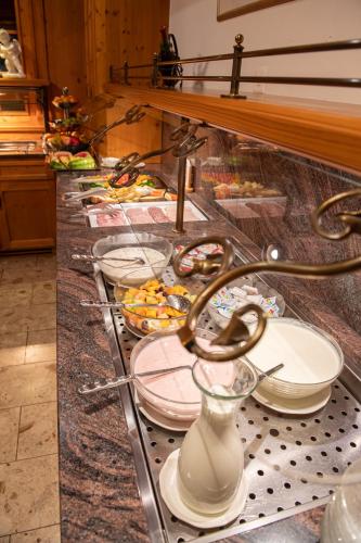 a buffet line with plates and bowls of food at Hotel Taescherhof in Täsch