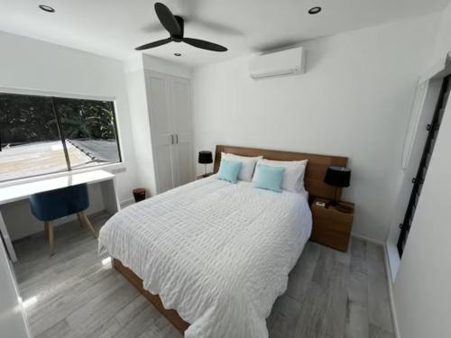 a bedroom with a bed and a ceiling fan at Indigo Apartment with Pool 200m to Beach in Palm Cove
