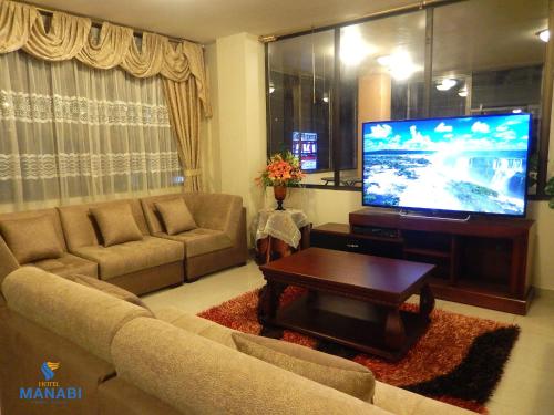 a living room with a couch and a flat screen tv at La Merced Plaza Hospedaje in Riobamba
