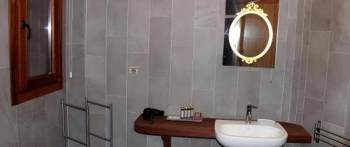 a bathroom with a white sink and a mirror at Hotel Rural Quercus Tierra in Garganta de los Montes