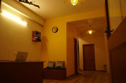 a room with yellow walls and a clock on the wall at Firefly Hostel in Manāli