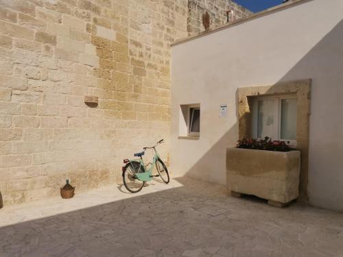 ein Fahrrad, das neben einer Wand mit einem Fenster parkt in der Unterkunft Dimora Margherita in Salento in Struda