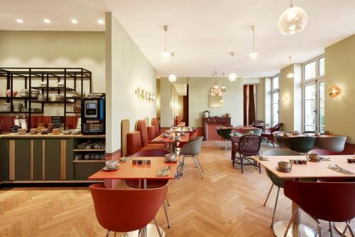 a restaurant with tables and chairs in a room at Hotel De Cambis in Avignon